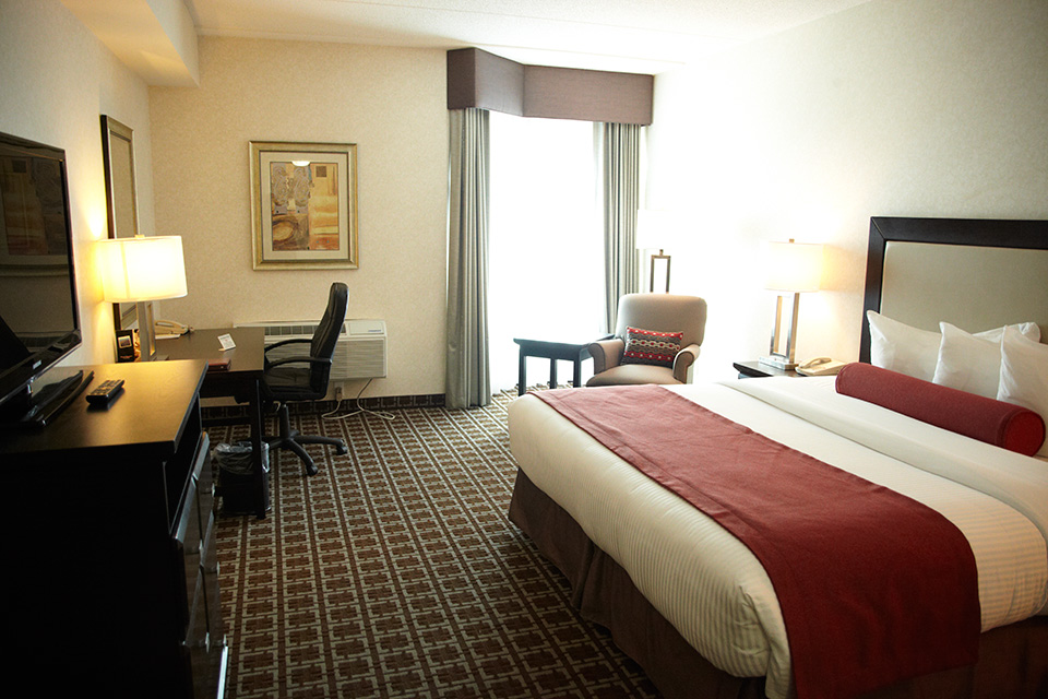 Bedroom with a king bed, a desk and a television