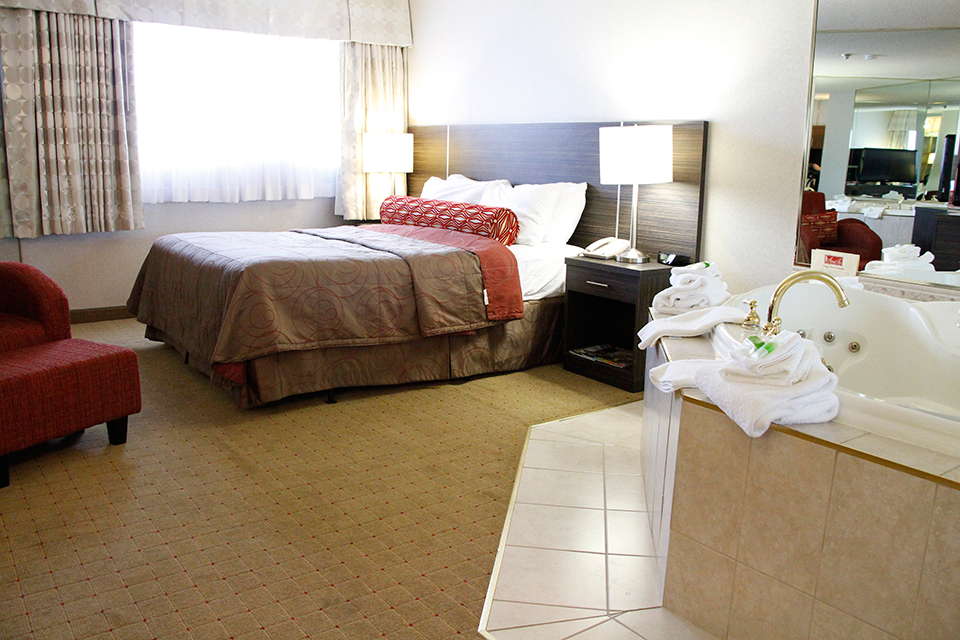 Bedroom with a king bed and a jacuzzi from the Admiral Inn Burlington Hotel