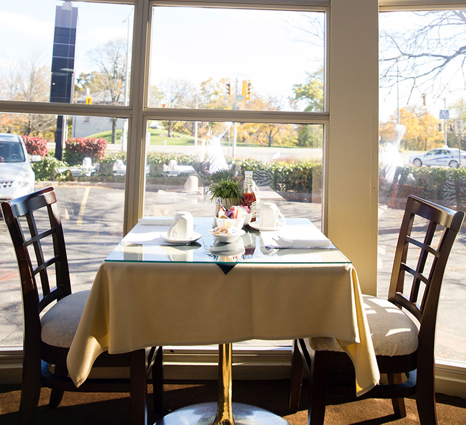 Table in the dining room of the Admiral Inn Hamilton Hotel with a view on the parking